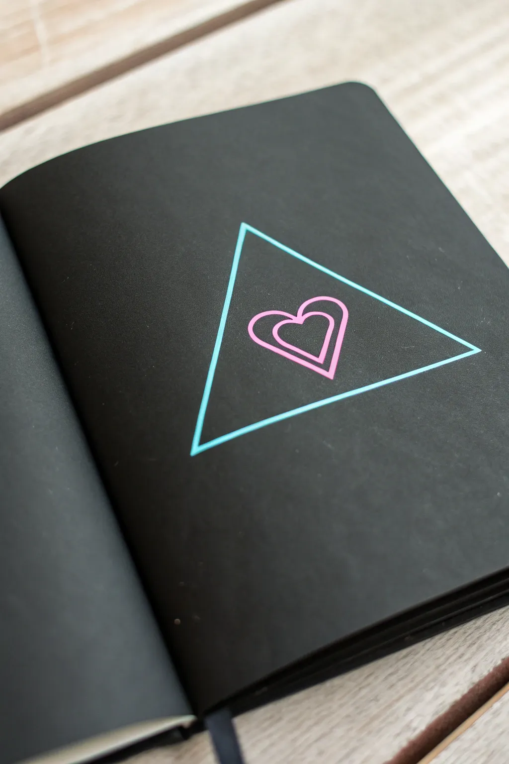 Minimal neon triangle frame with a tiny heart icon, bold glow on matte black for chic contrast.