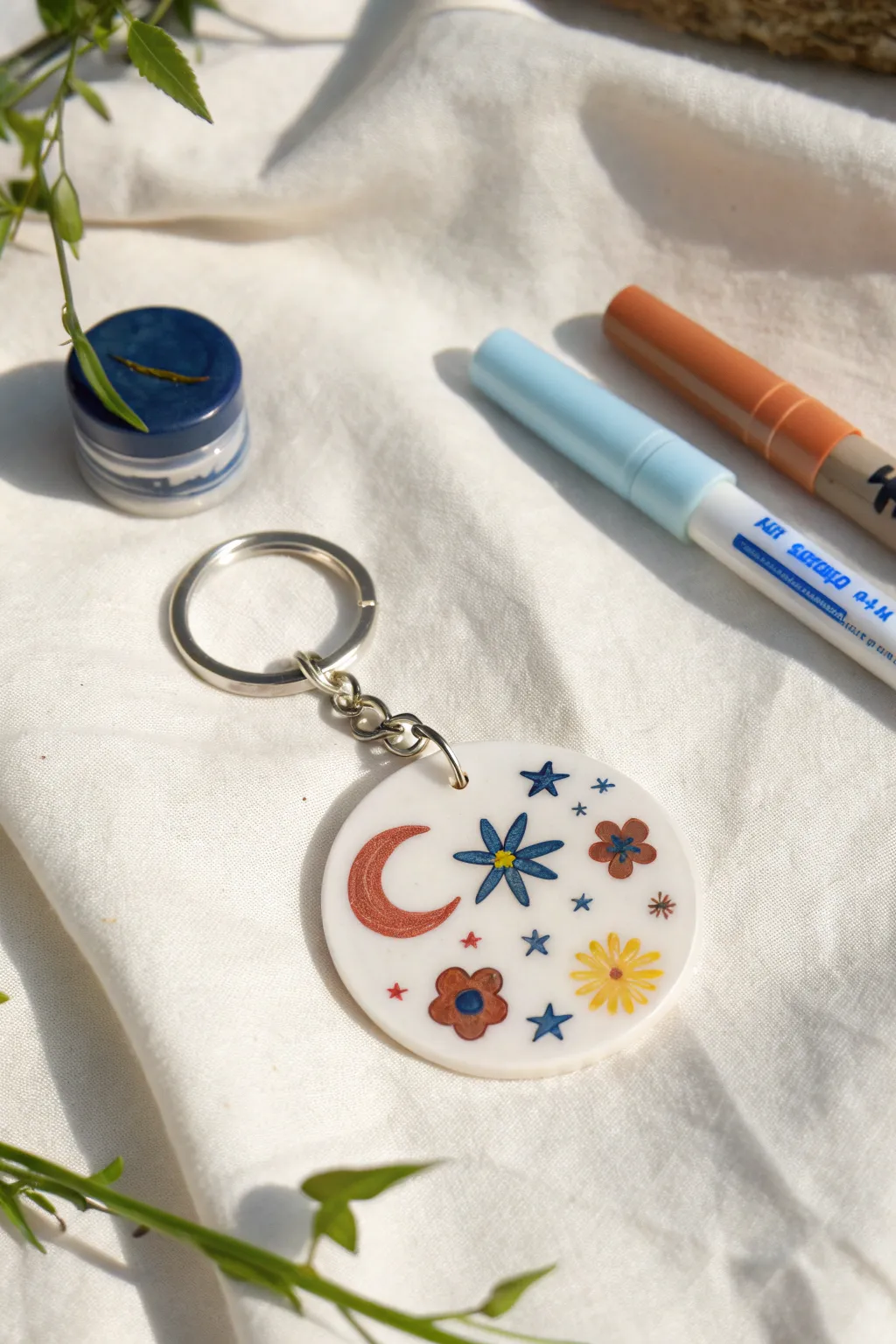 Tiny paint marker icons turn a simple charm into a bold, boho-minimal keychain DIY.