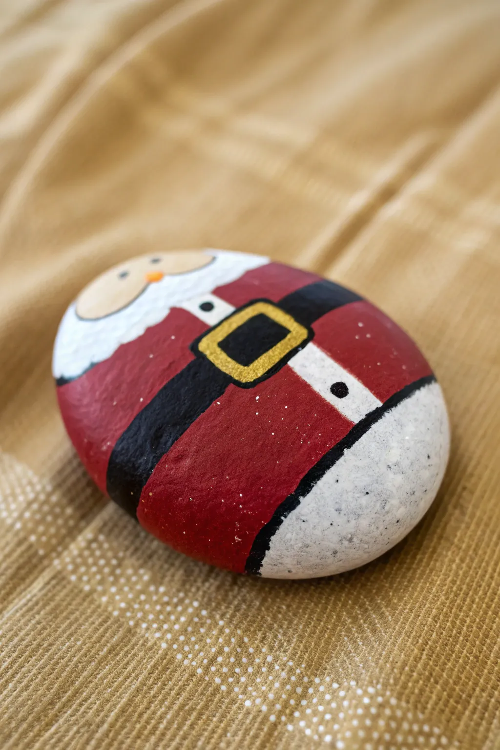 Santa suit rock painting idea: bold red, black belt, and clean white trim in minimalist style