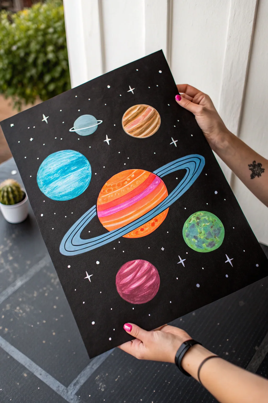 Neon planets on black make a bold solar system painting with crisp stars and glowing rings.