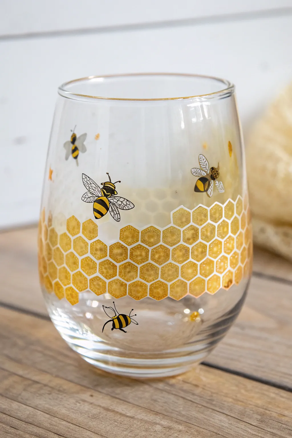 Bumblebee and honeycomb dot painting on a stemless wine glass with cozy minimal boho contrast