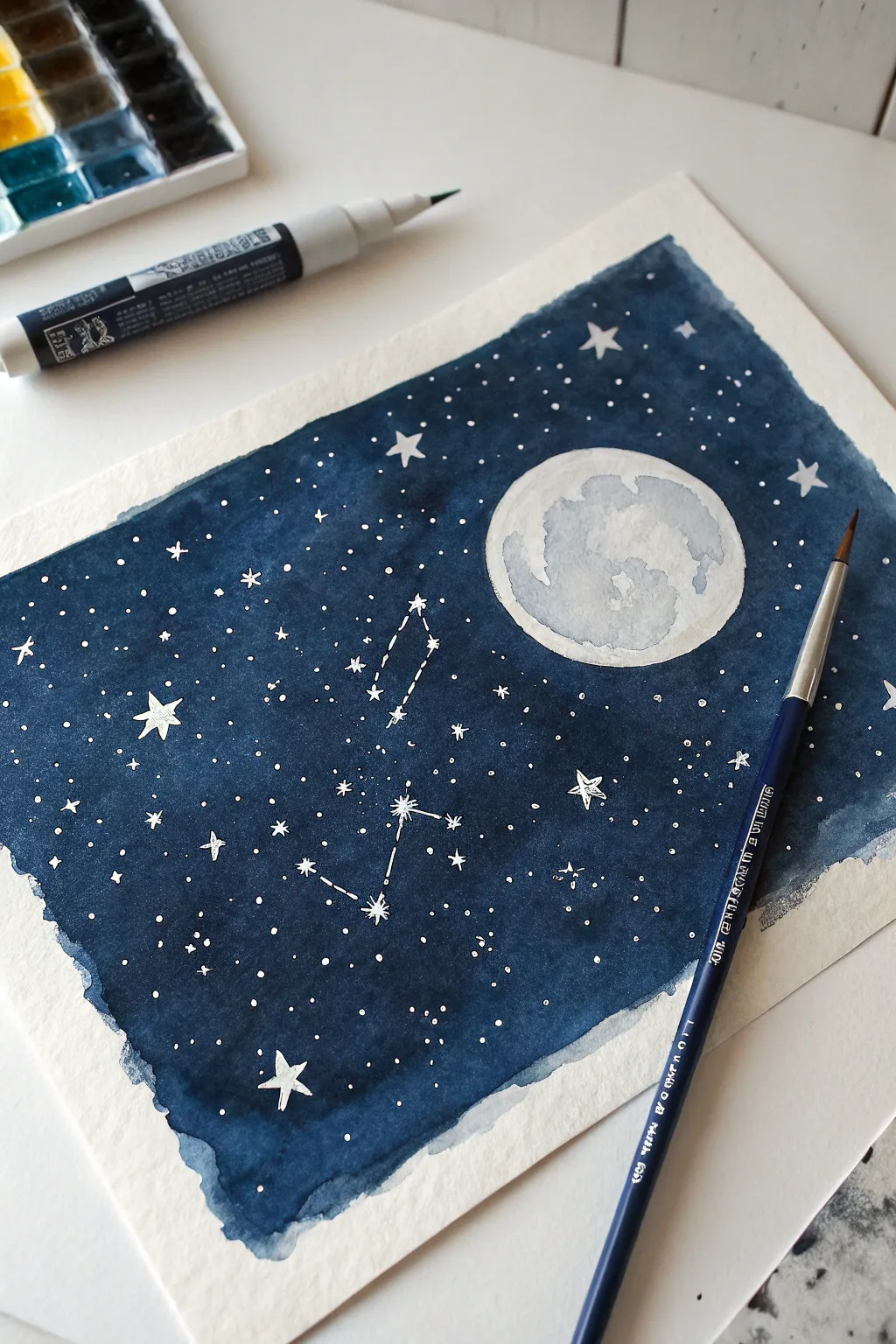 Crayon-resist night sky with indigo tempera wash, crisp white stars, and soft brushy texture