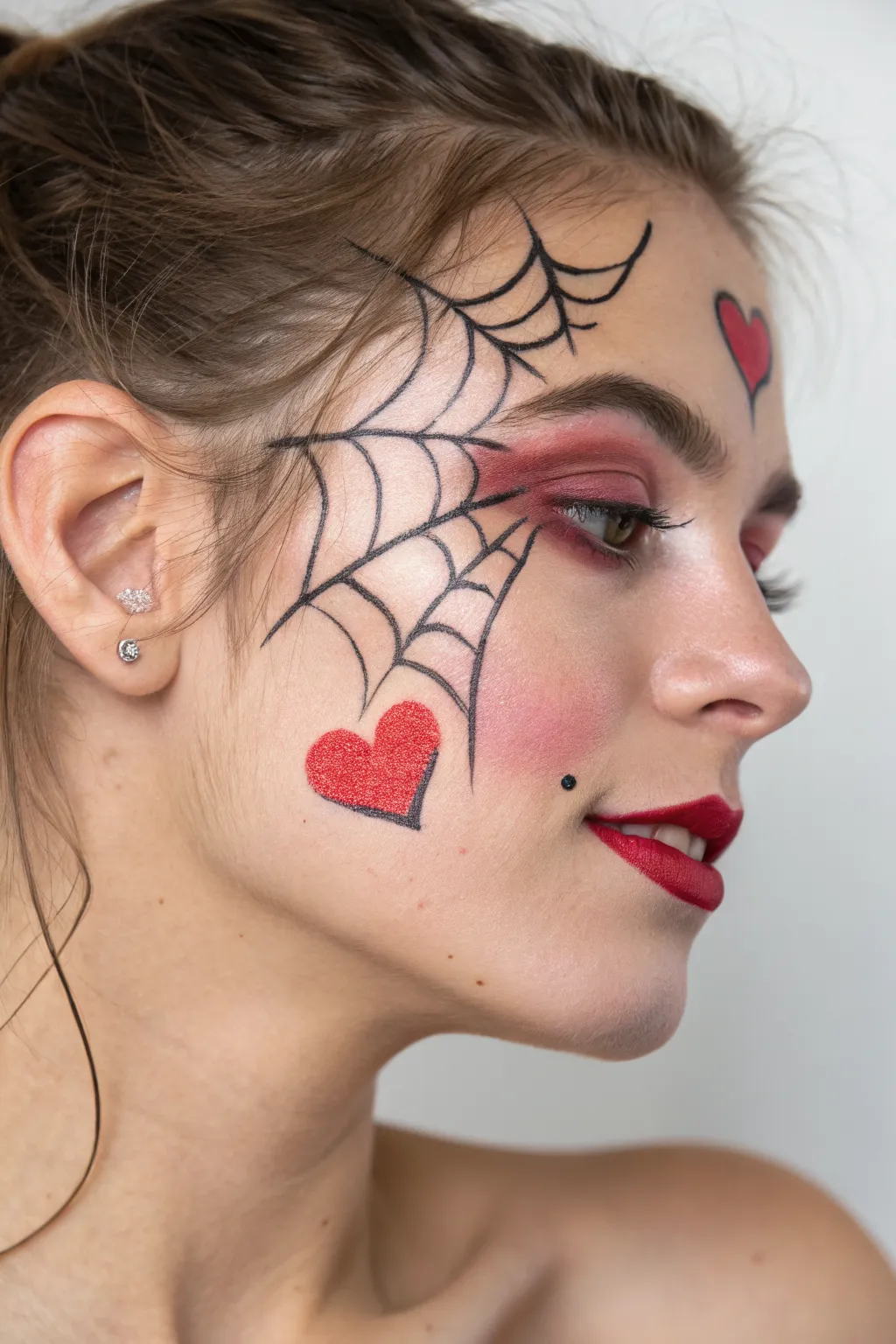 Edgy Heart Web face paint: bold black lines with a red-pink glow for modern romance
