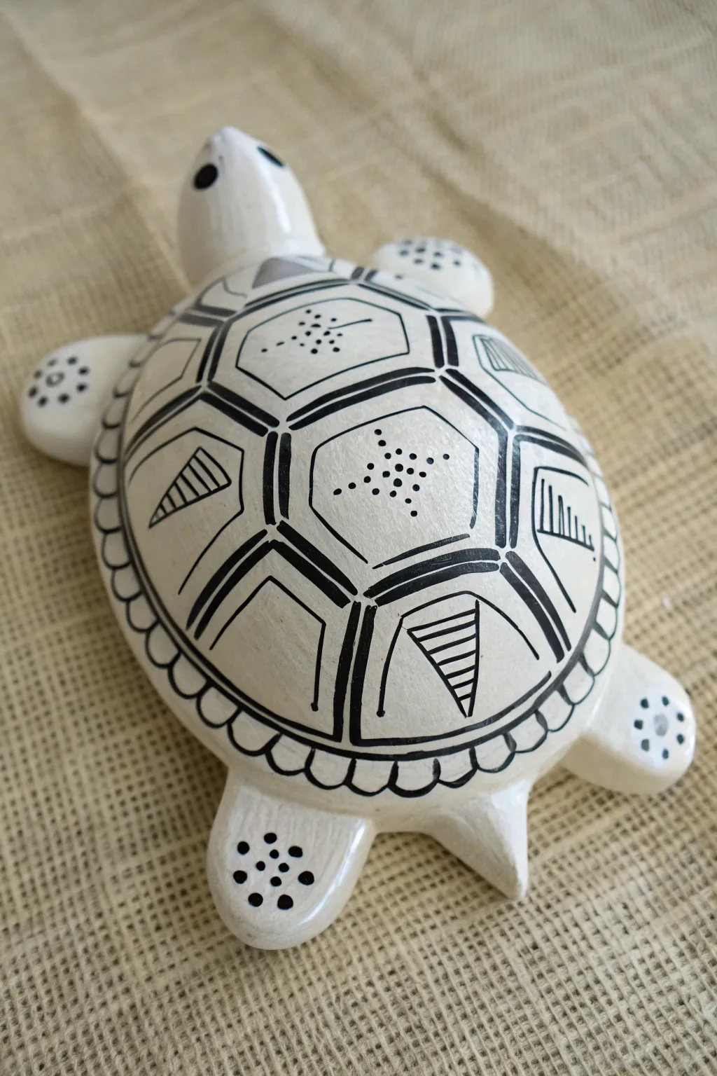 Airy negative-space line art on a matte white ceramic turtle shell, minimalist Scandinavian boho