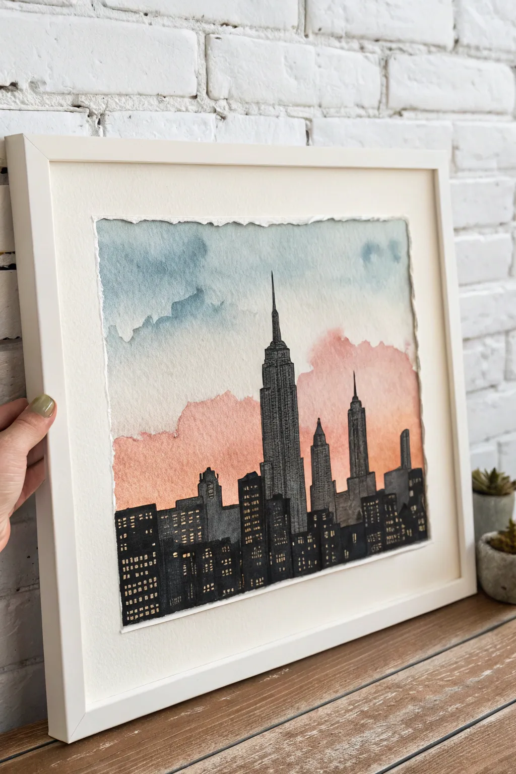 Torn-paper skyline over a soft gradient sky, finished with minimalist ink windows and streetlights.