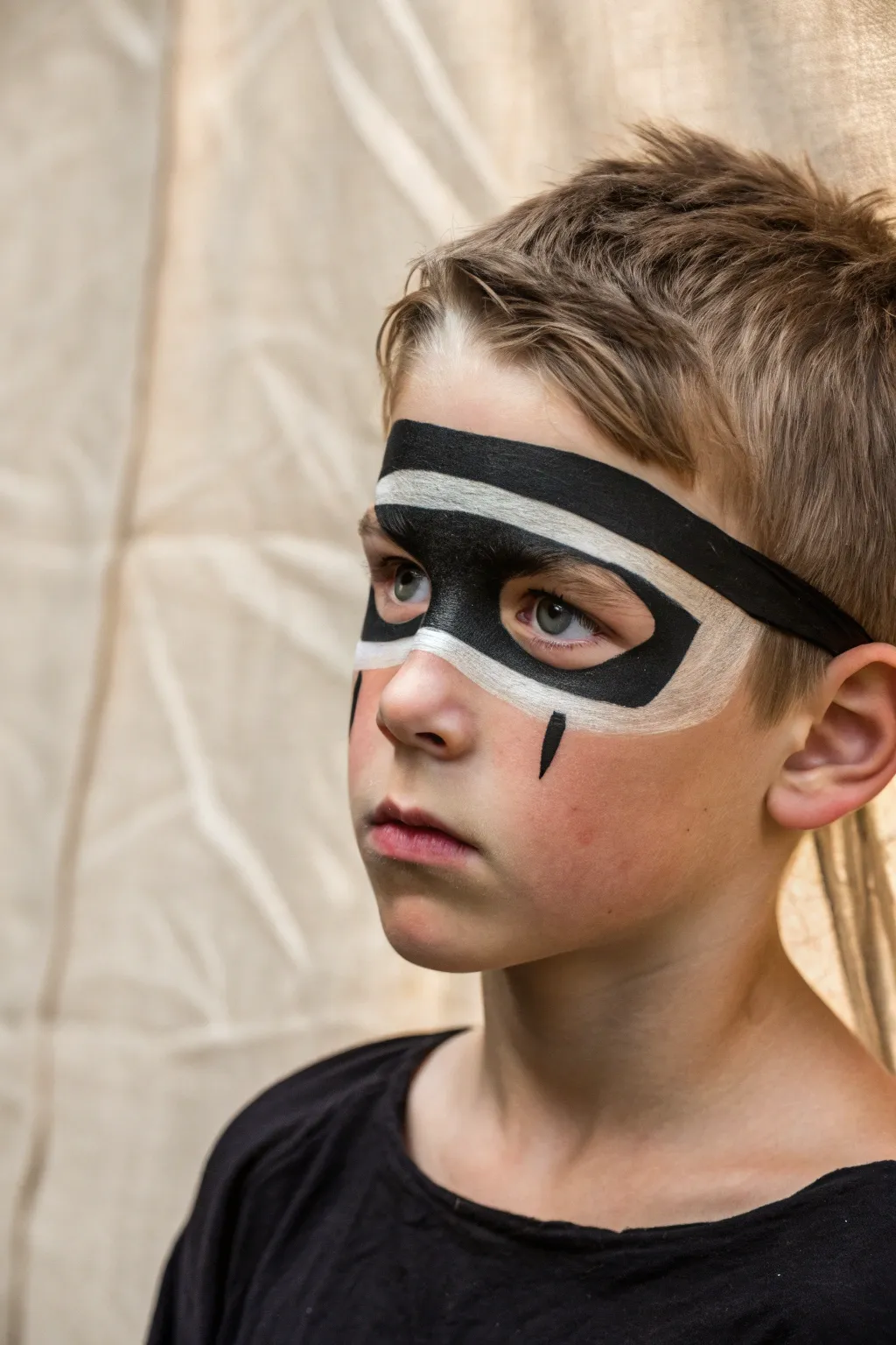 Bold ninja mask face paint for boys, simple black band and sharp brows, dramatic yet clean.