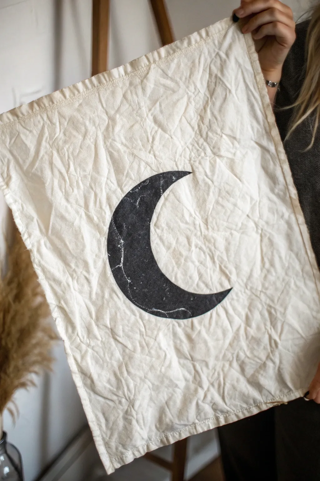 Crumpled-paper grunge layer with a bold moon icon, minimalist yet textured and striking