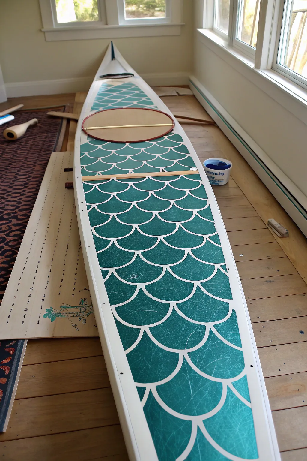 Fish-scale stencil fade on a kayak deck, crisp edges and layered color in a calm minimal style