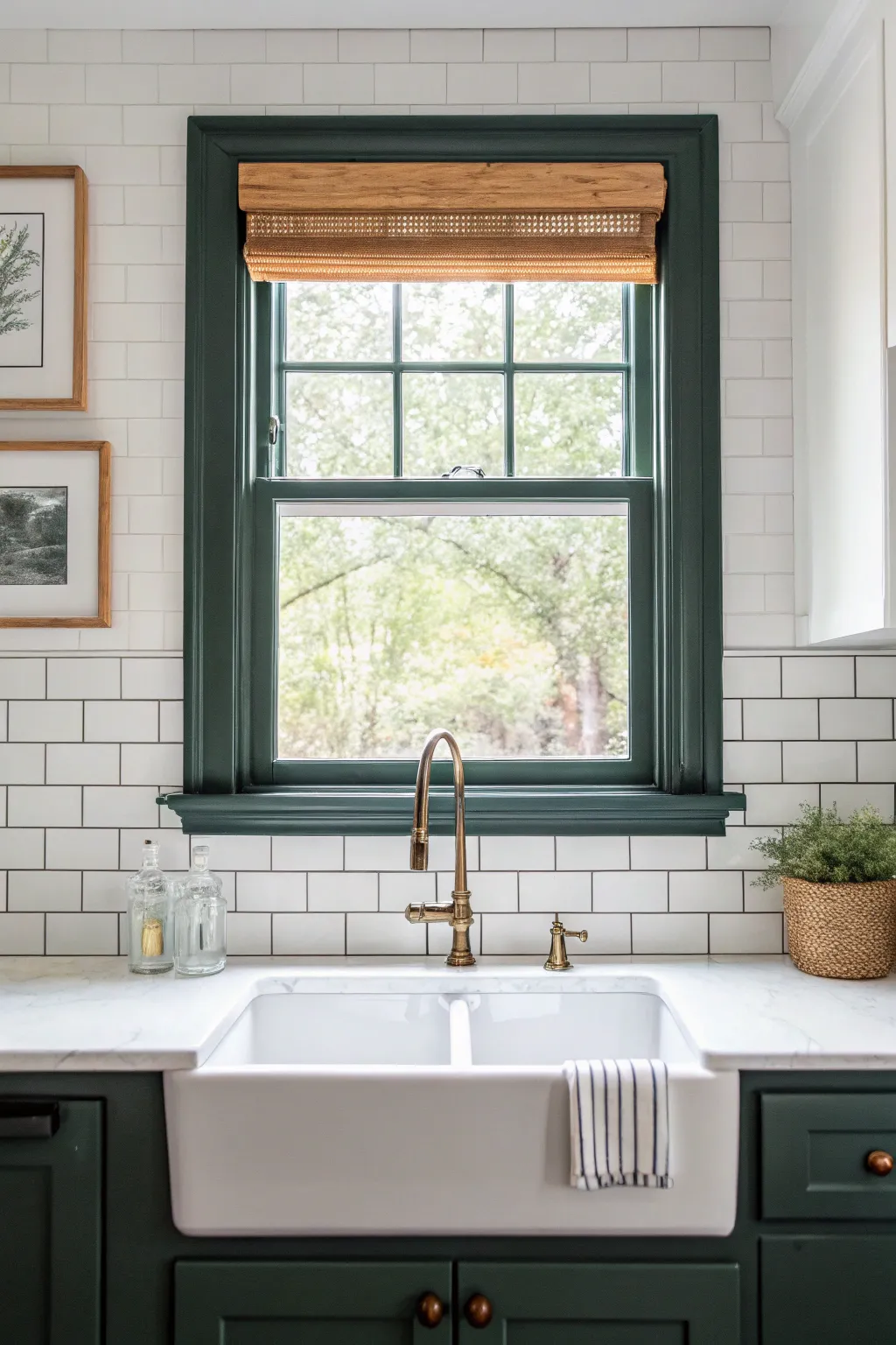 Crisp painted window trim in deep green adds bold contrast above a calm Scandinavian sink.