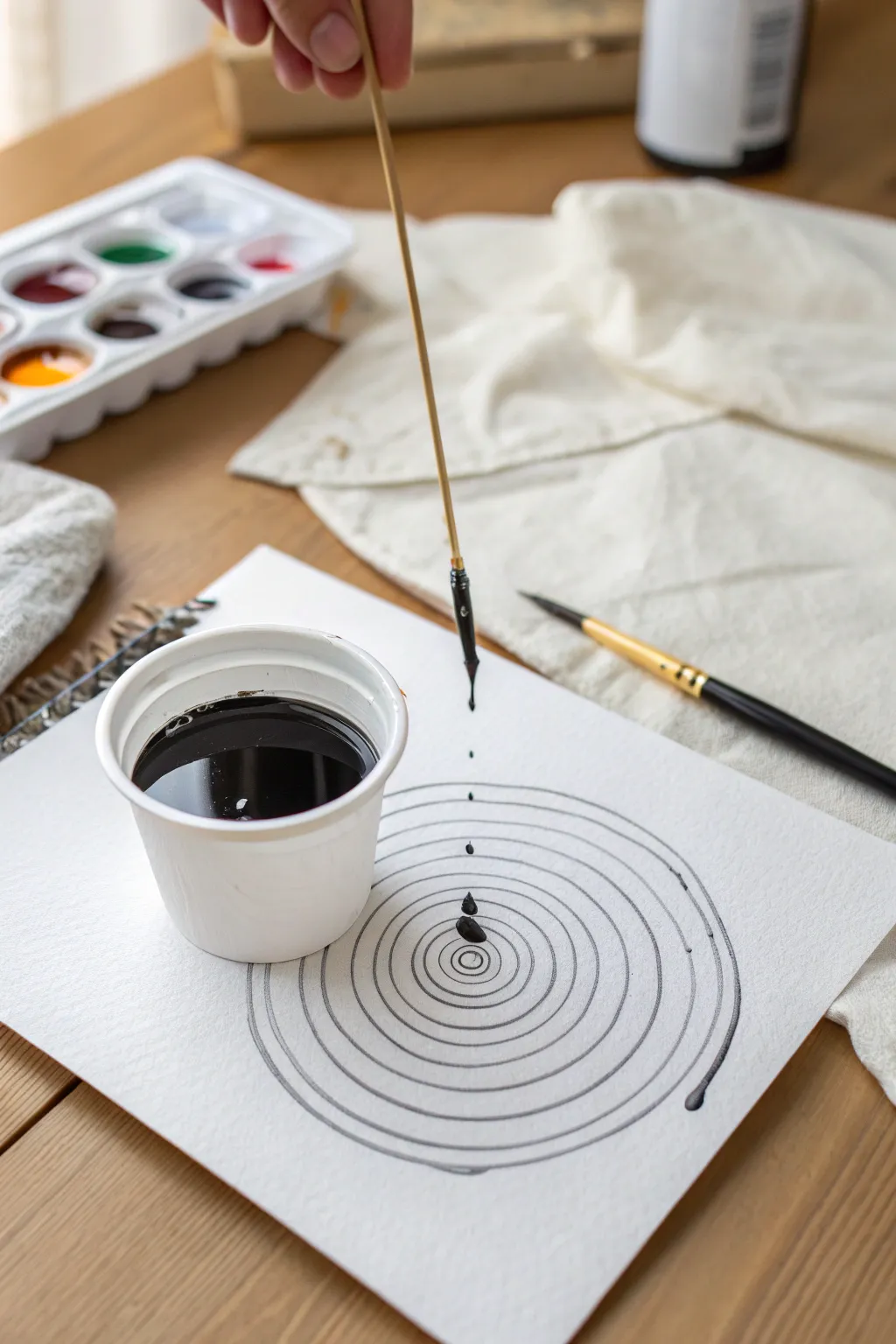 Mesmerizing pendulum drip loops on crisp white paper, a minimalist craft moment in motion.
