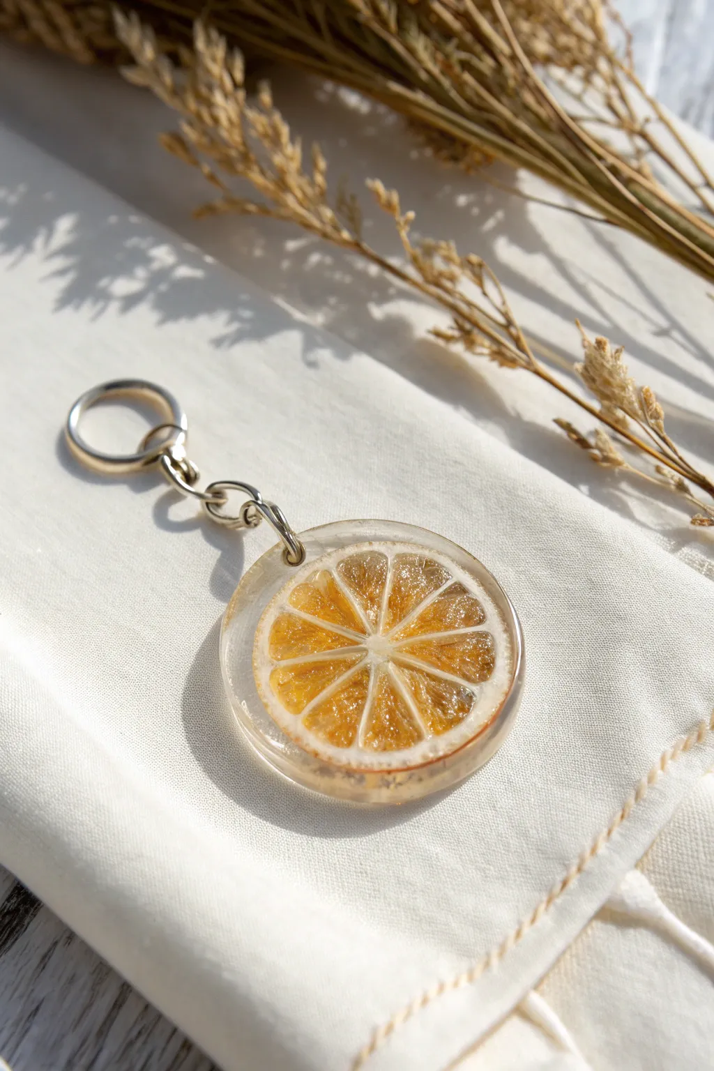 Mini citrus slice resin charm with glossy depth, styled in a clean Scandinavian boho flat lay