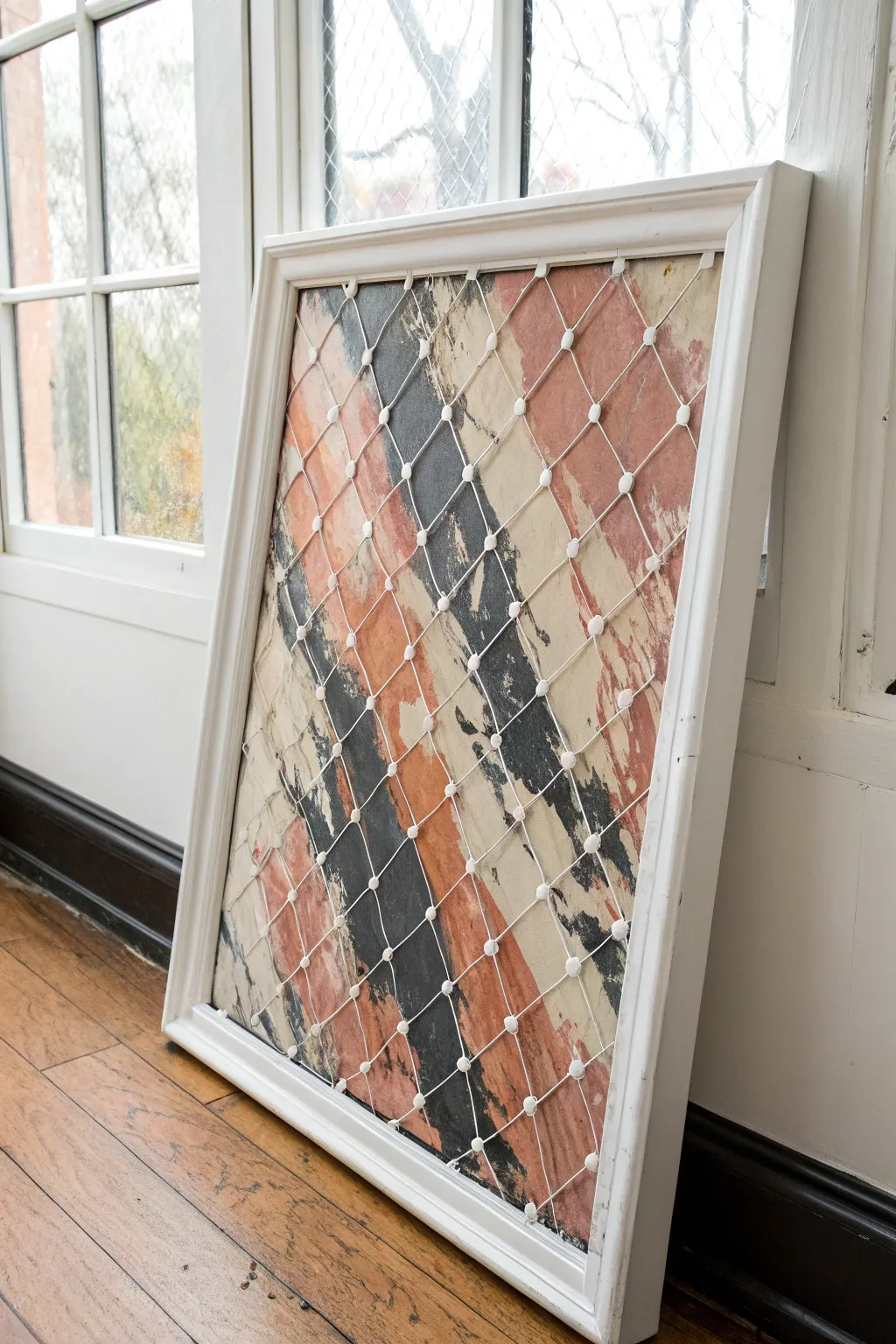 Controlled splatters and dragged strokes cling to the mesh for a modern screen painting study.