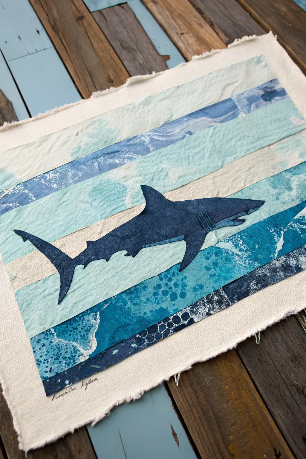 Minimal mixed media shark collage with torn-paper ocean layers, bubbles, and rich indigo contrast.