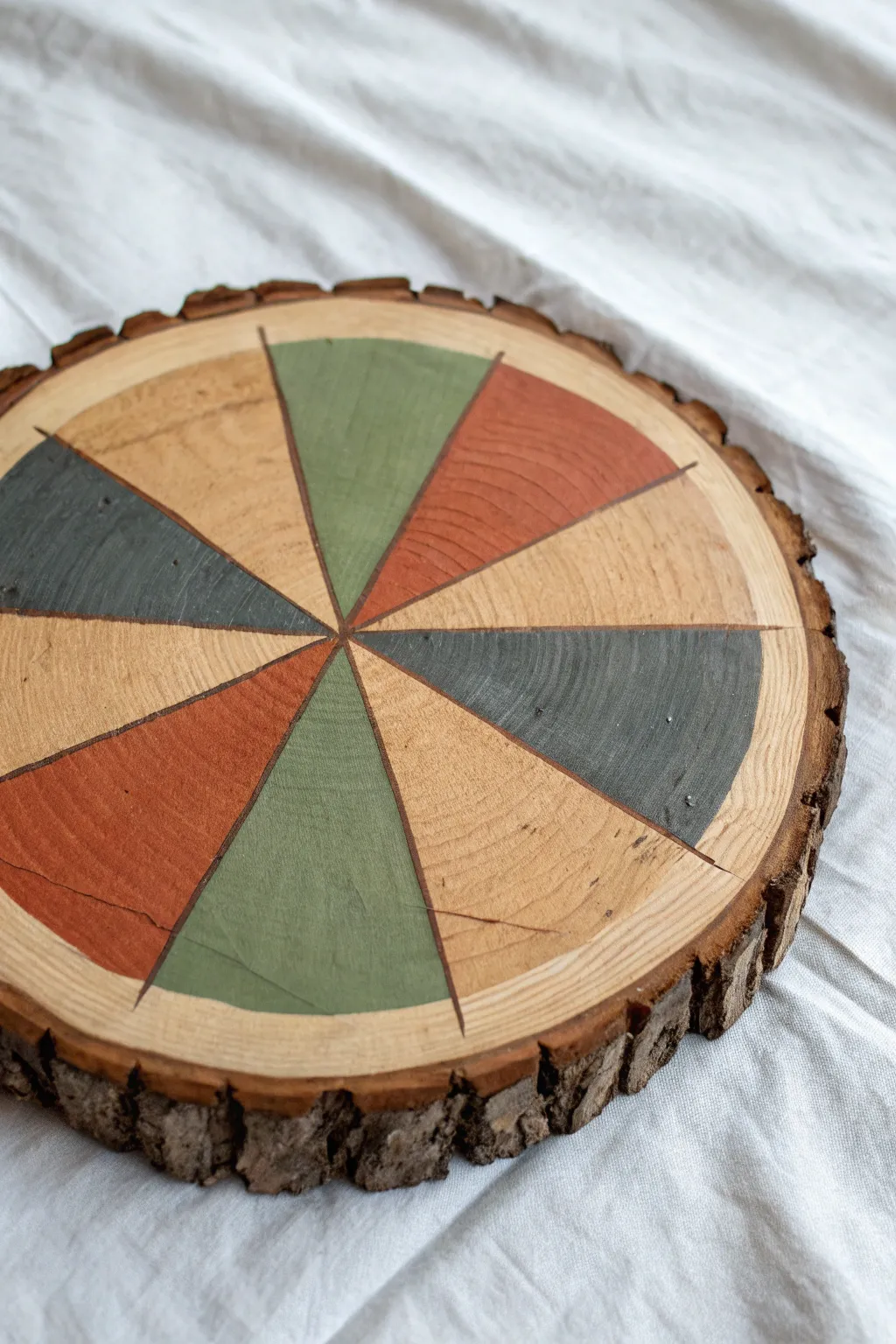 Geometric color-block rings on a raw bark wood slice for a modern boho minimalist look