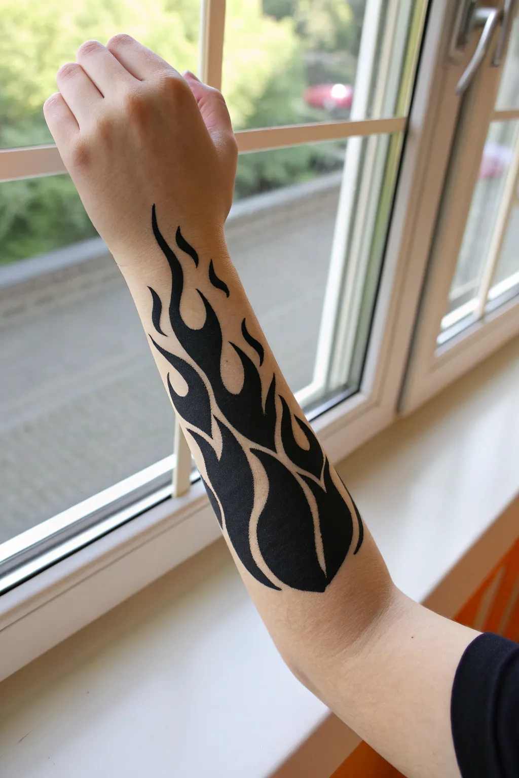 Easy tribal flame forearm paint: bold matte black with fine ivory outline, minimalist boho vibe