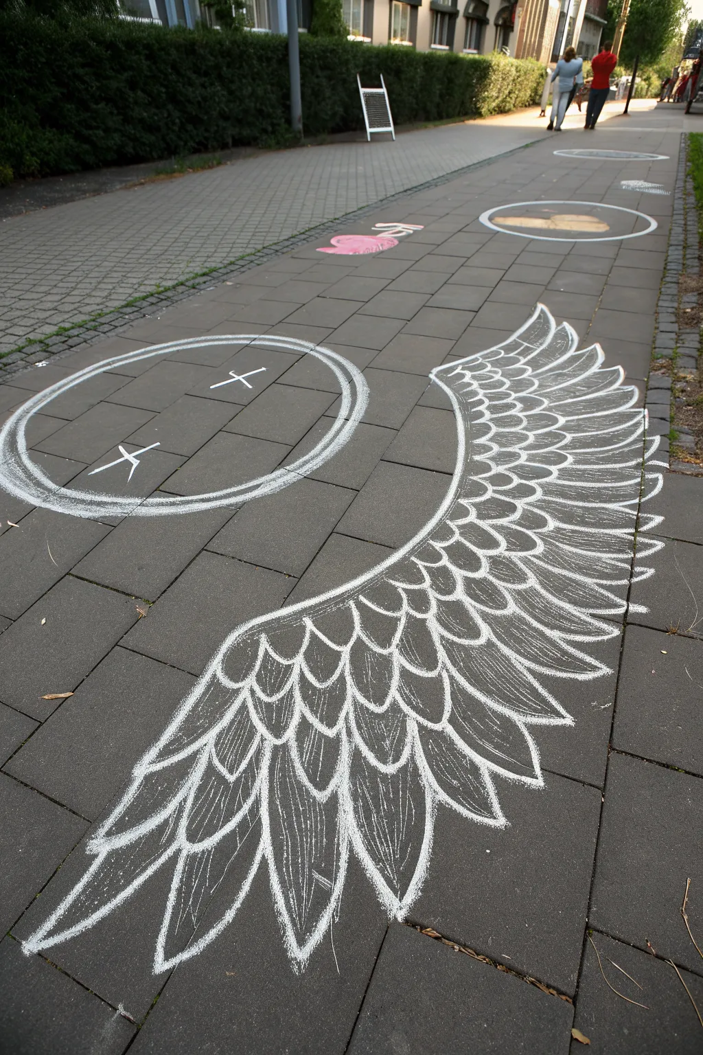 Chalk angel wings with tiny smiling feathers, perfect for a playful top-down photo spot