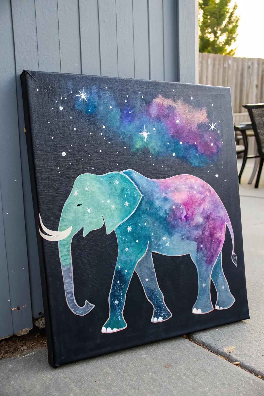 Minimalist elephant silhouette with galaxy nebula colors and star splatter for easy acrylic practice.