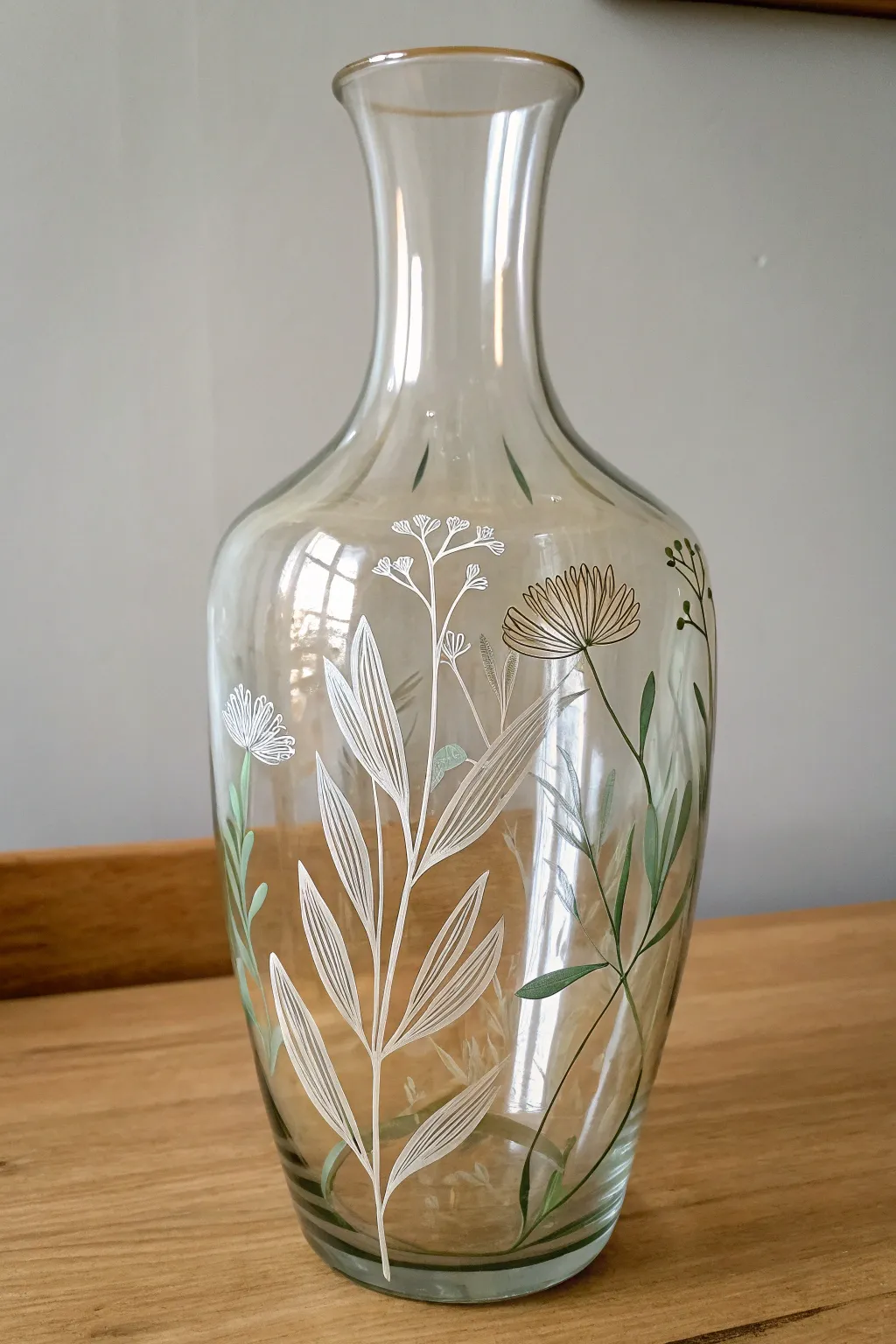Reverse paint a minimal botanical motif inside a clear vase for a chic Scandinavian look