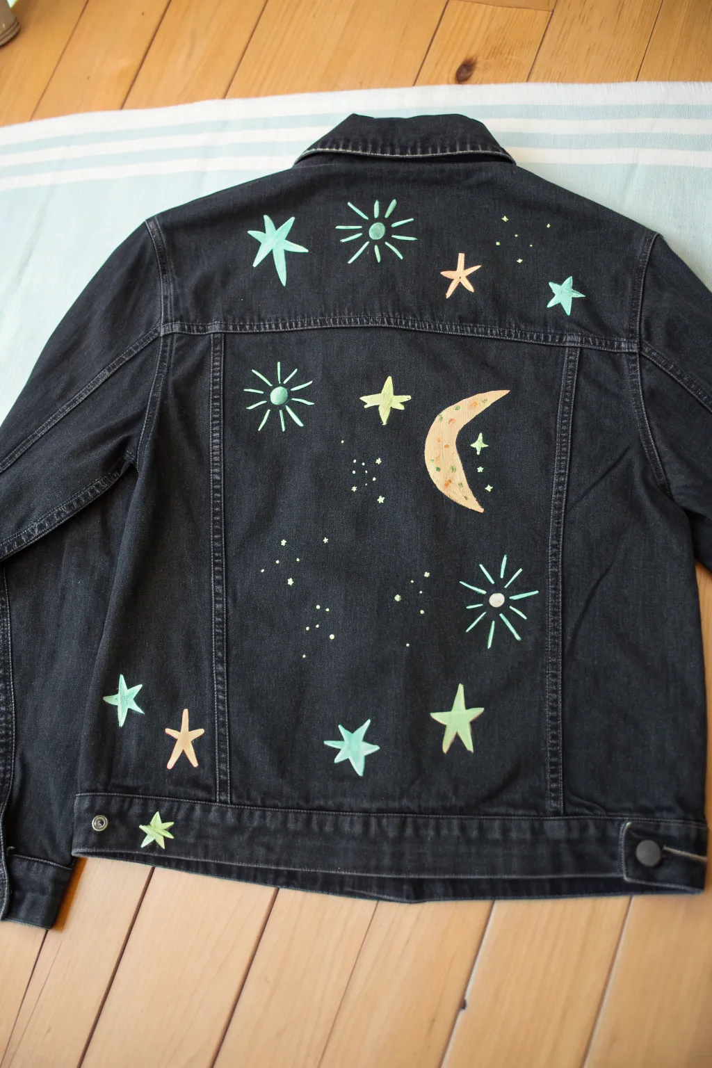 Paint glow halos on a dark jacket for night-ready highlights with minimalist, boho vibes.