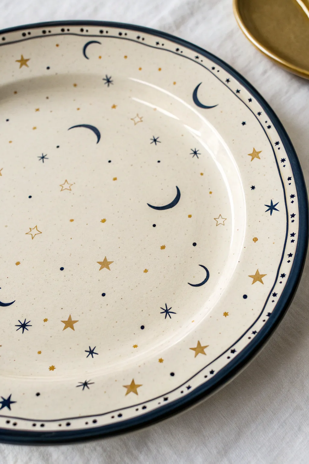 Paint a celestial night-sky border: indigo rim, tiny stars and moons, soft metallic accents.