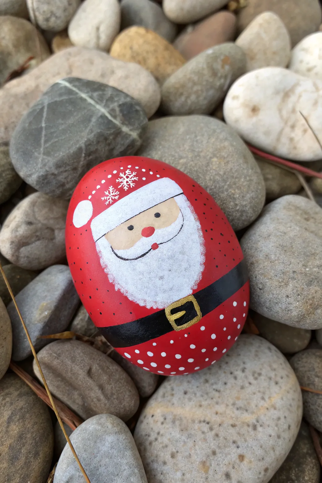 Minimal Santa rock with metallic buckle and tiny sparkles, lit by soft angled daylight