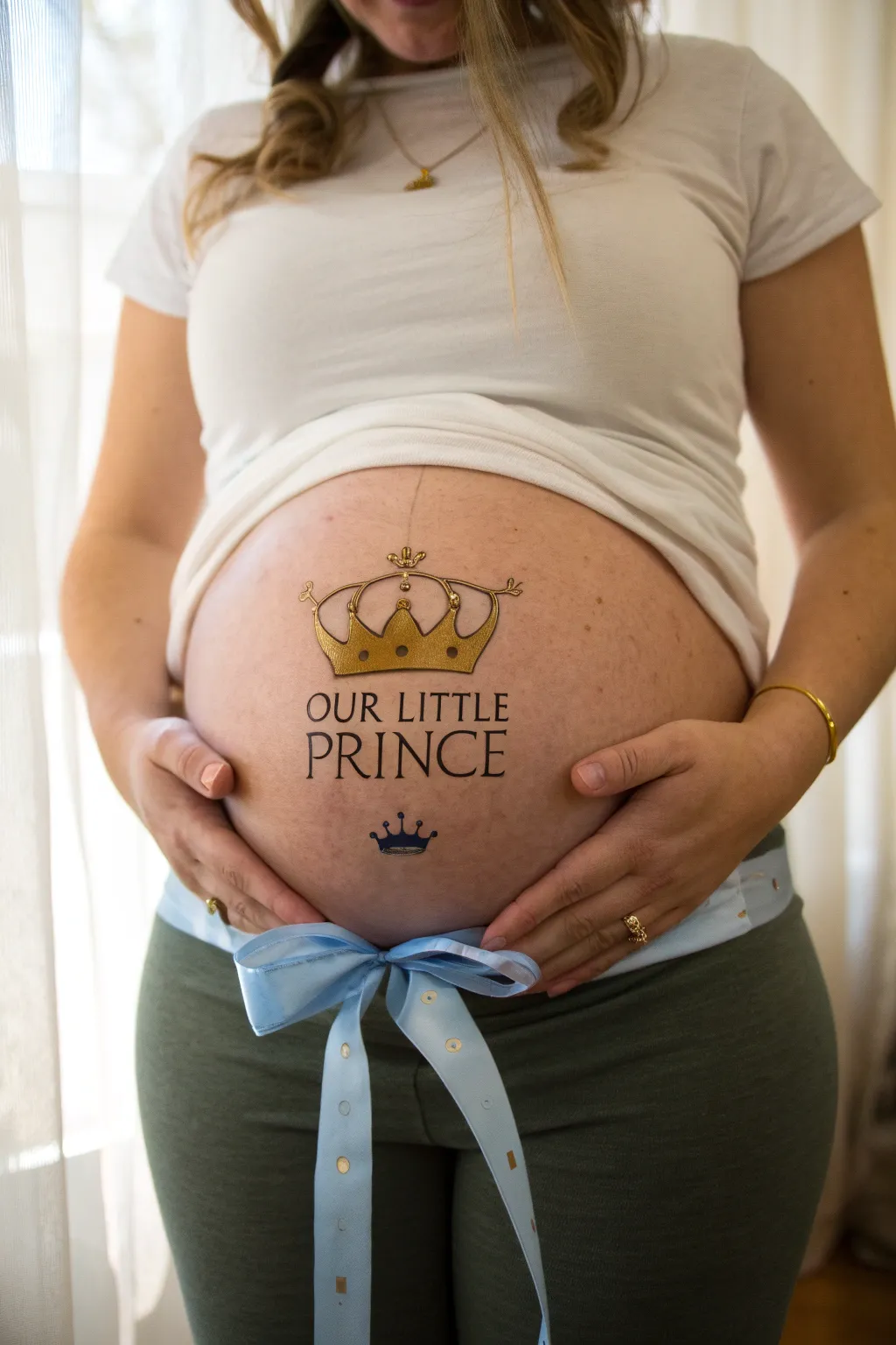 Minimal gold crown with blue ribbons for a sweet baby boy belly painting, modern and serene