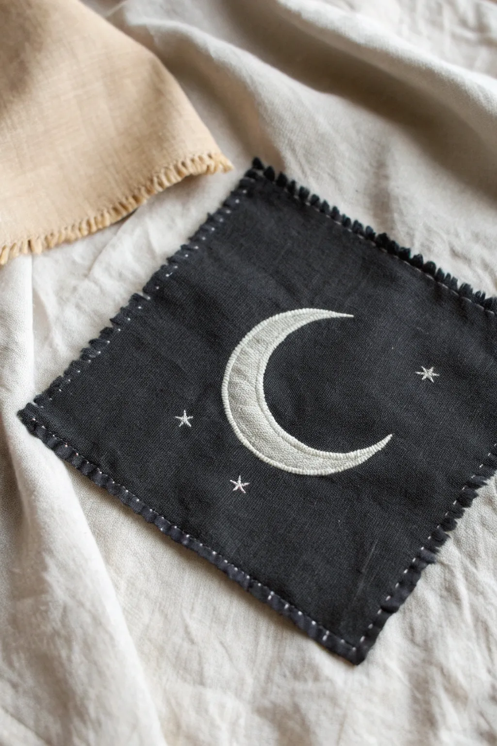 Mixed-media magic: bleach-painted moon + hand stitches, crisp contrast and cozy linen texture.