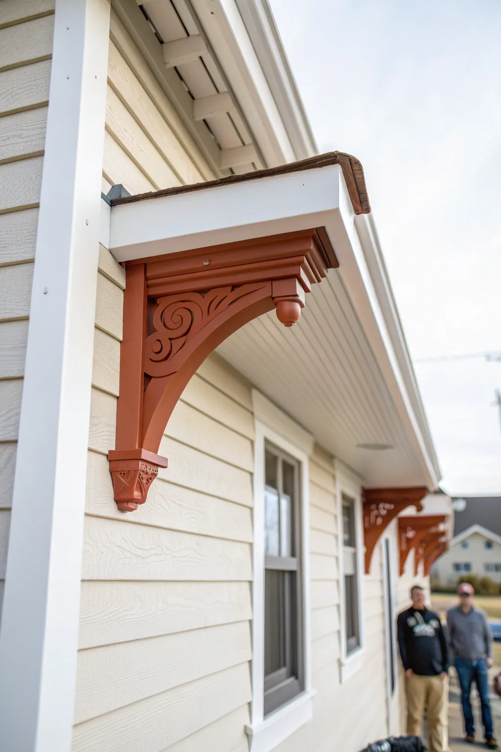 Terracotta accent corbel detail pops against warm white siding for an elegant, crafted look.