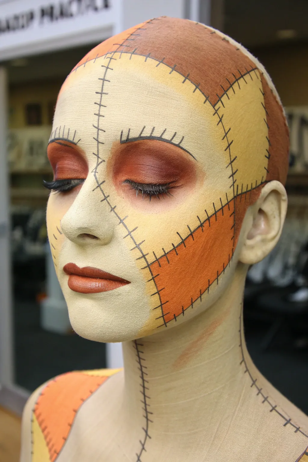 Harvest ombré patchwork scarecrow face paint with neat black stitches for a cozy minimalist look