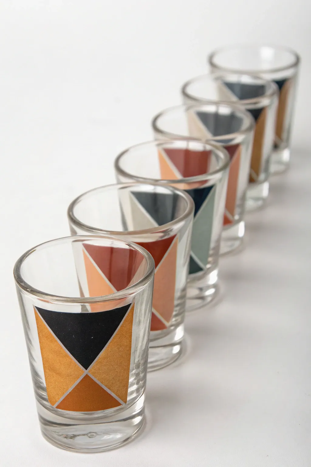 Geometric color blocks line up across a minimalist shot glass set for a modern painted look.