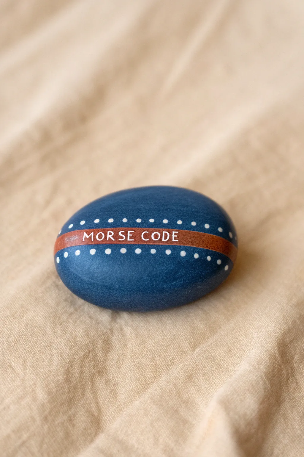 Minimal Morse-code rock painting hides a best-friend message in bold dots and dashes.