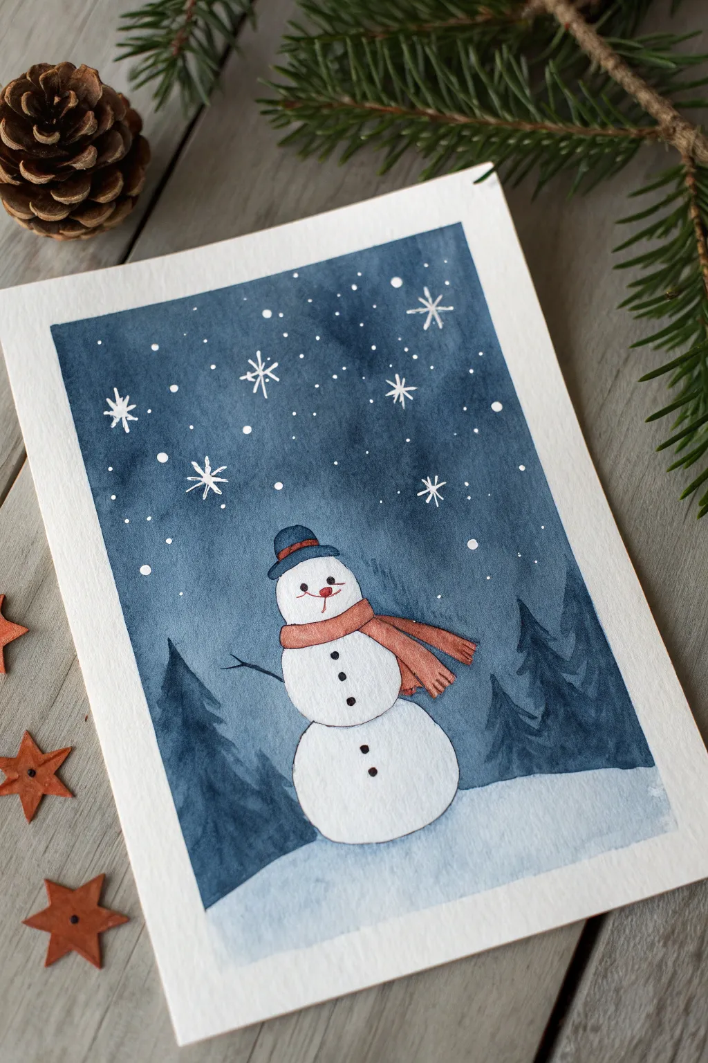 Negative space snowman in a starry night wash with a simple scarf outline and bold contrast.