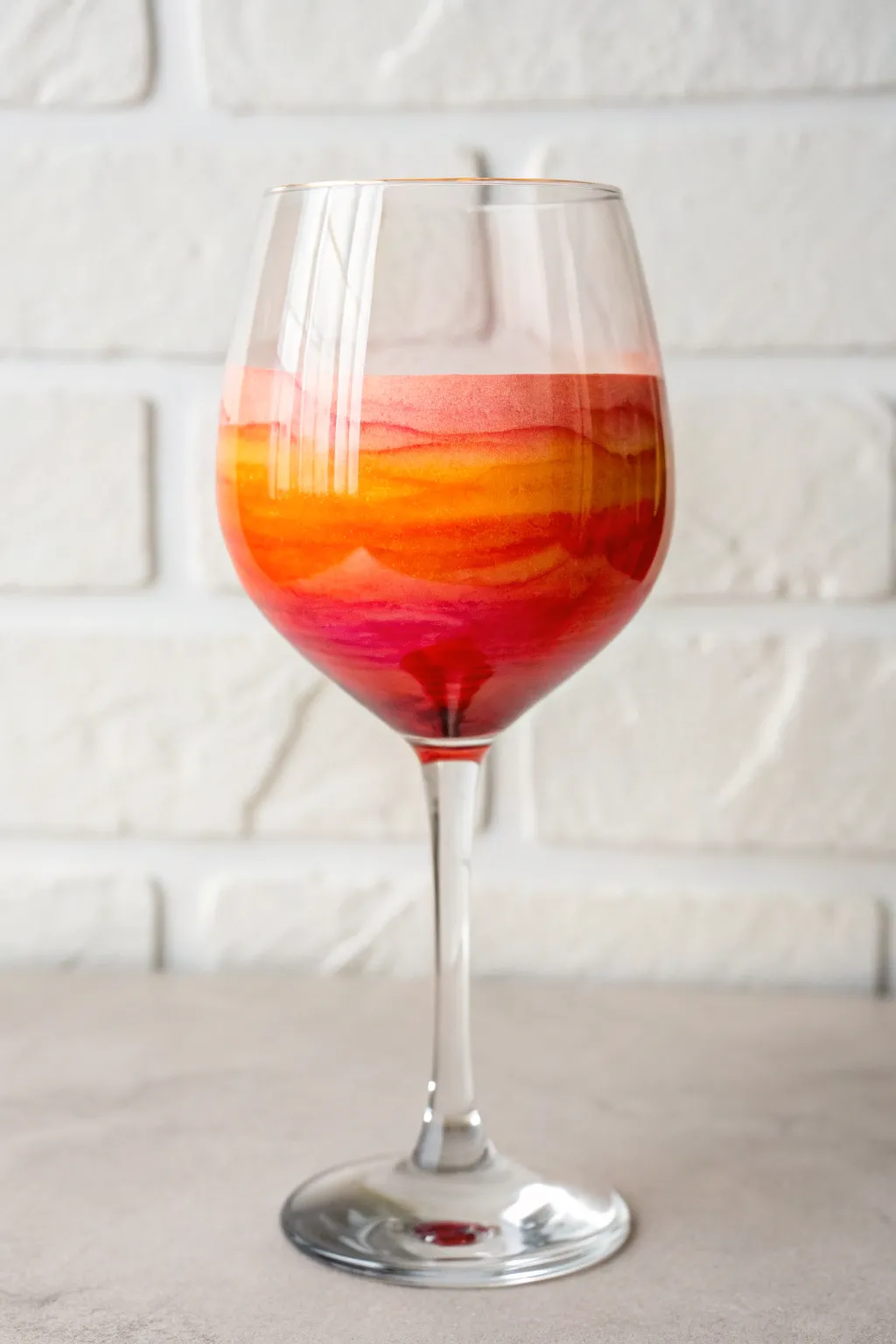Capture the golden hour in your hand with this dreamy DIY sunset ombre wine glass idea.