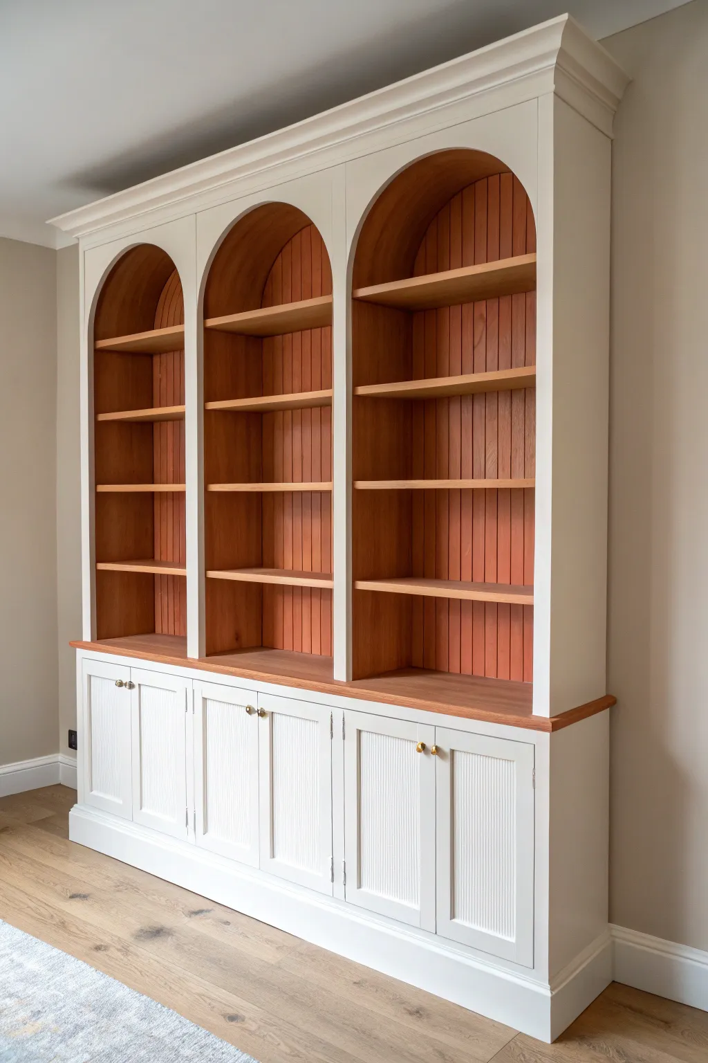 Painted arches create an elegant niche illusion for a bold, minimalist built-in bookshelf refresh.
