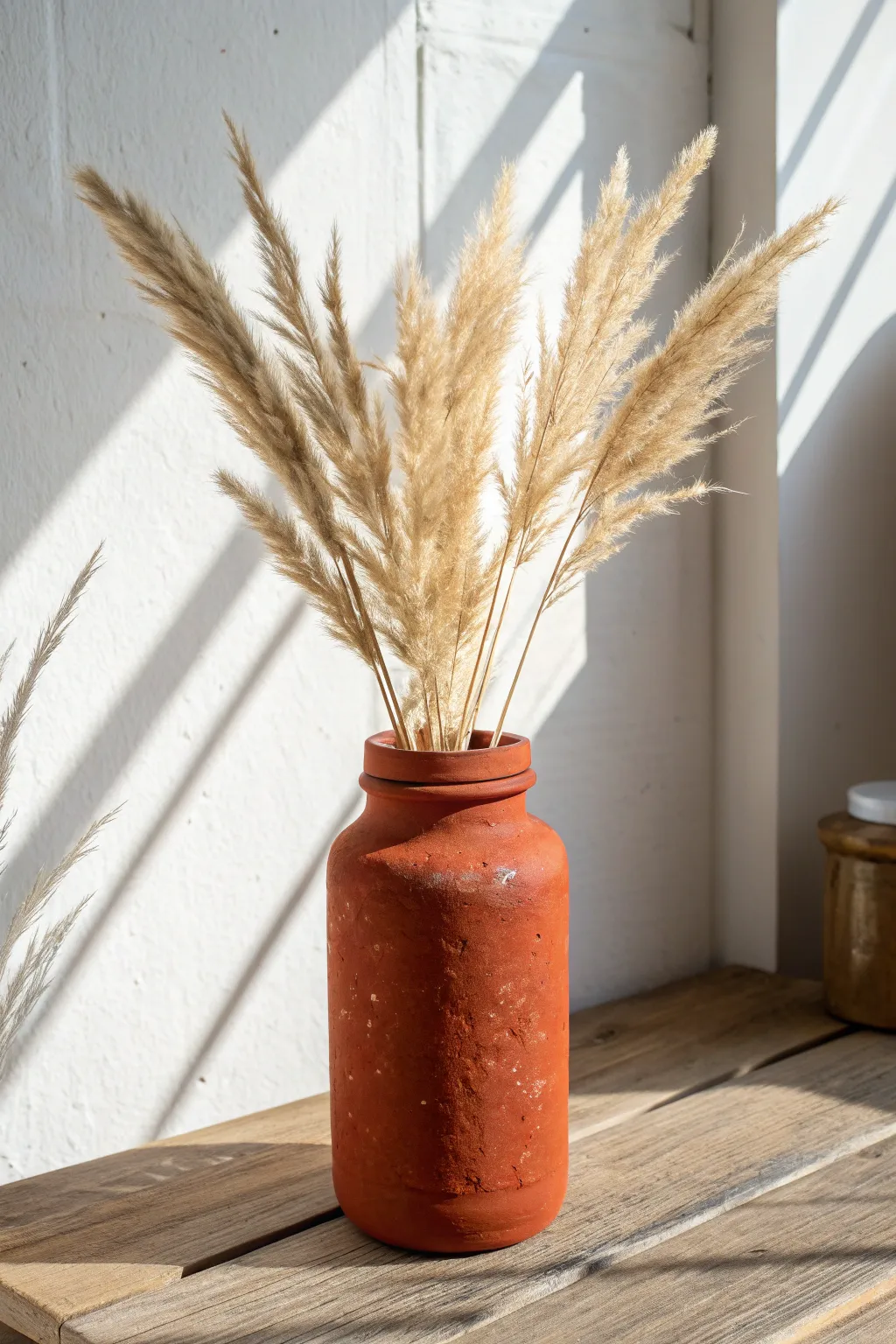 Turn plain glass jars into trendy, textured faux terracotta vases with this easy DIY.