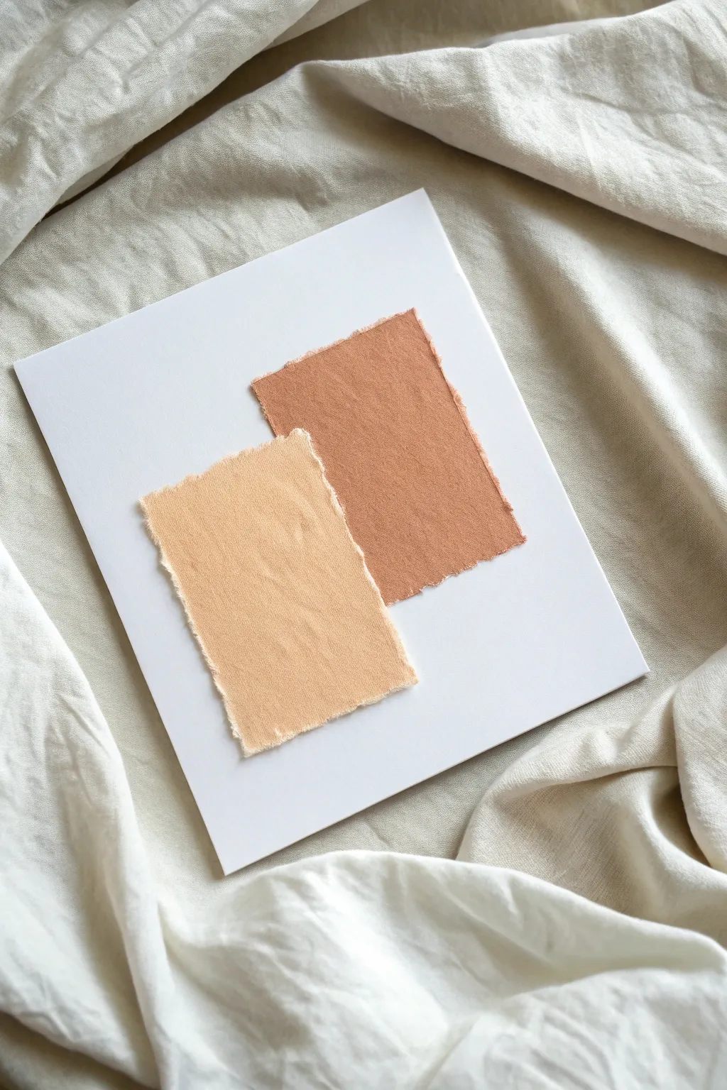 Minimal two-paper collage: torn neutral and muted terracotta shapes on crisp white space.