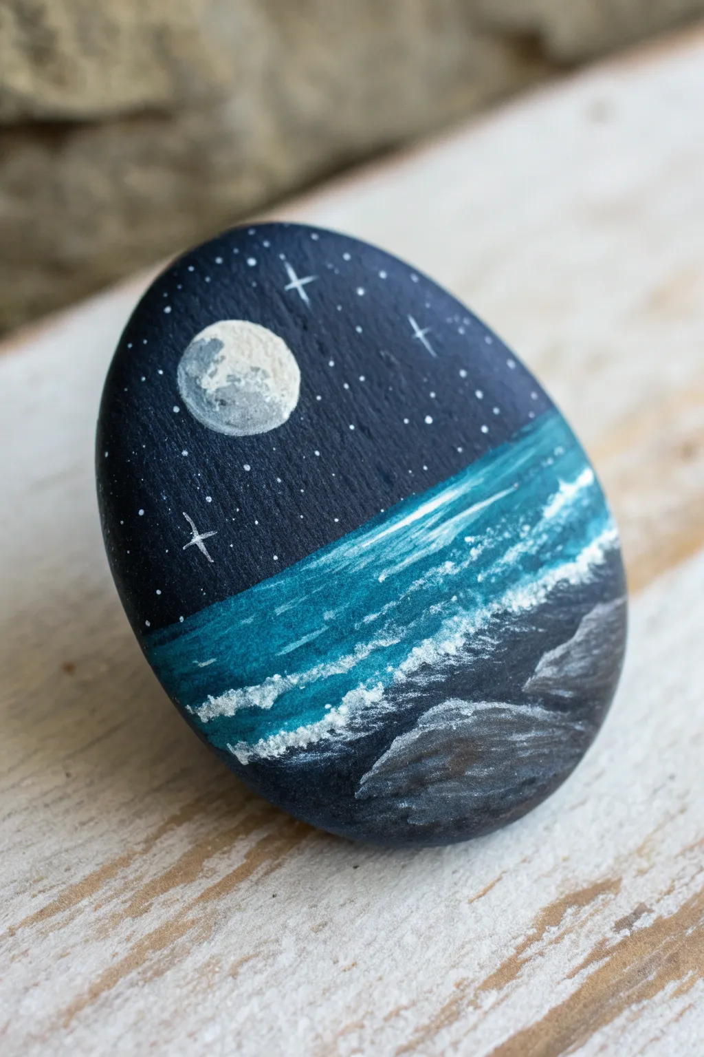 Paint a night beach on one smooth rock: tiny moon and bold white moonpath shimmer.