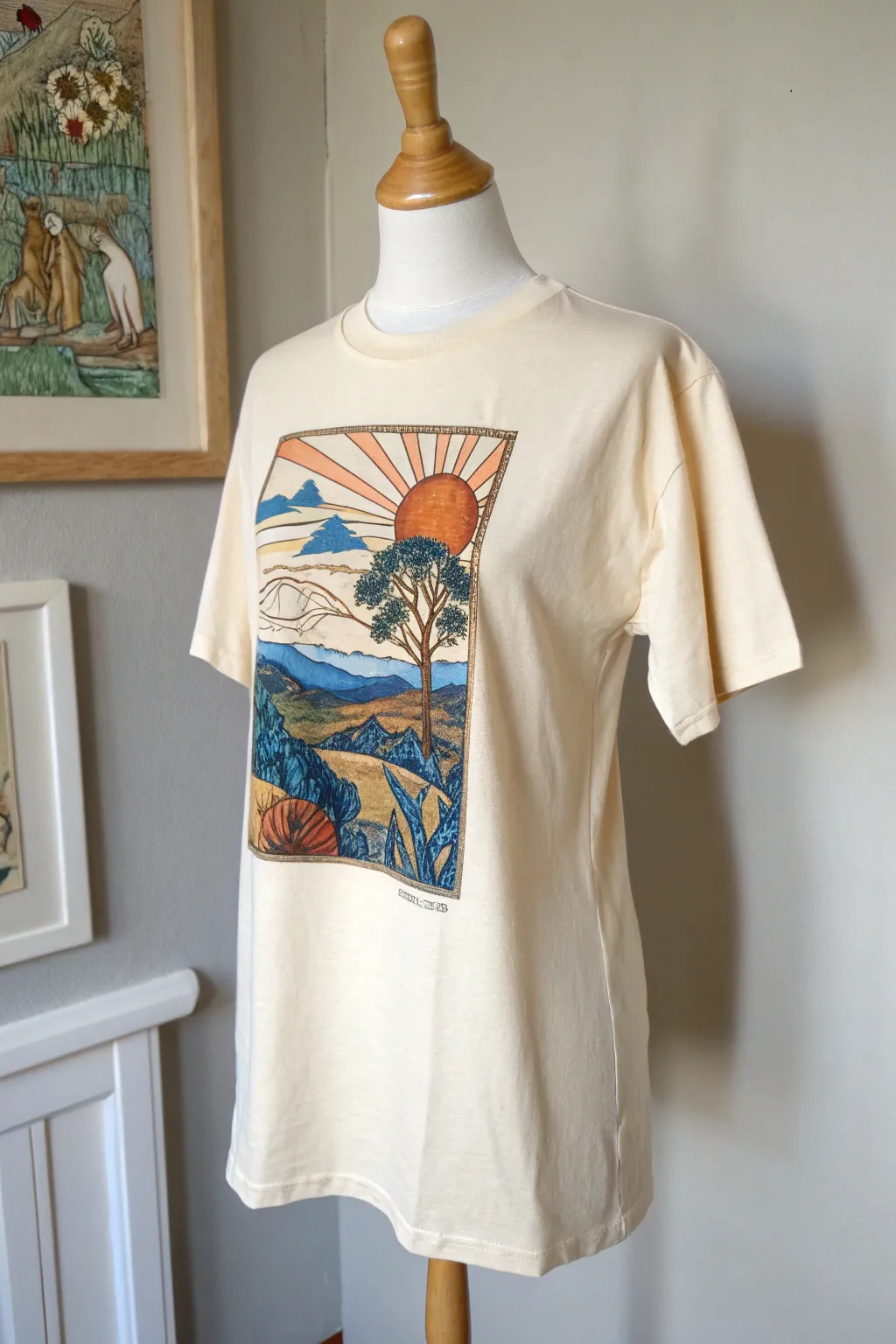 Wrap-around story scene tee: a tiny illustrated world rising from hem to chest in bold color