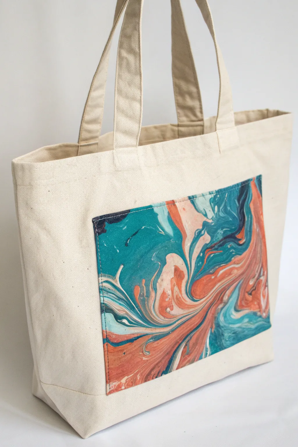 Modern marbled pour-painted panel on a cotton tote, bold color swirls with clean minimal style.