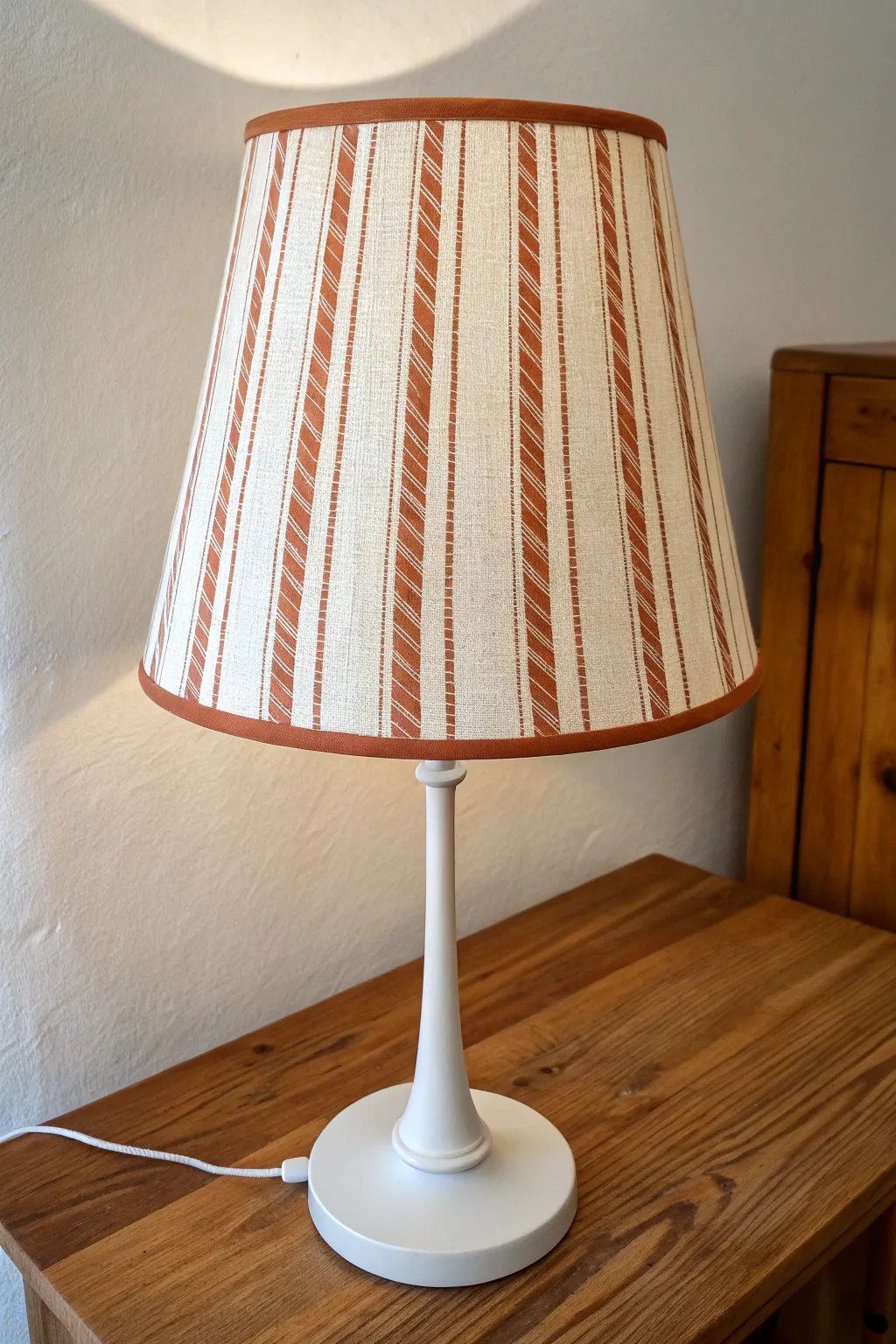 Simple vertical stripes on a painted acrylic lampshade, glowing softly for an easy DIY look.