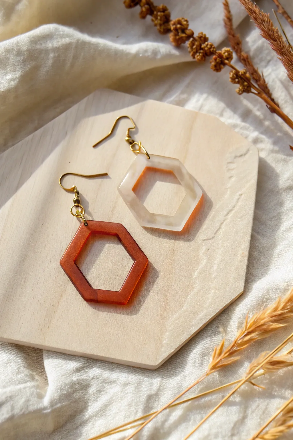 Lightweight geometric acrylic earrings on textured paper, minimal Scandinavian palette with boho warmth