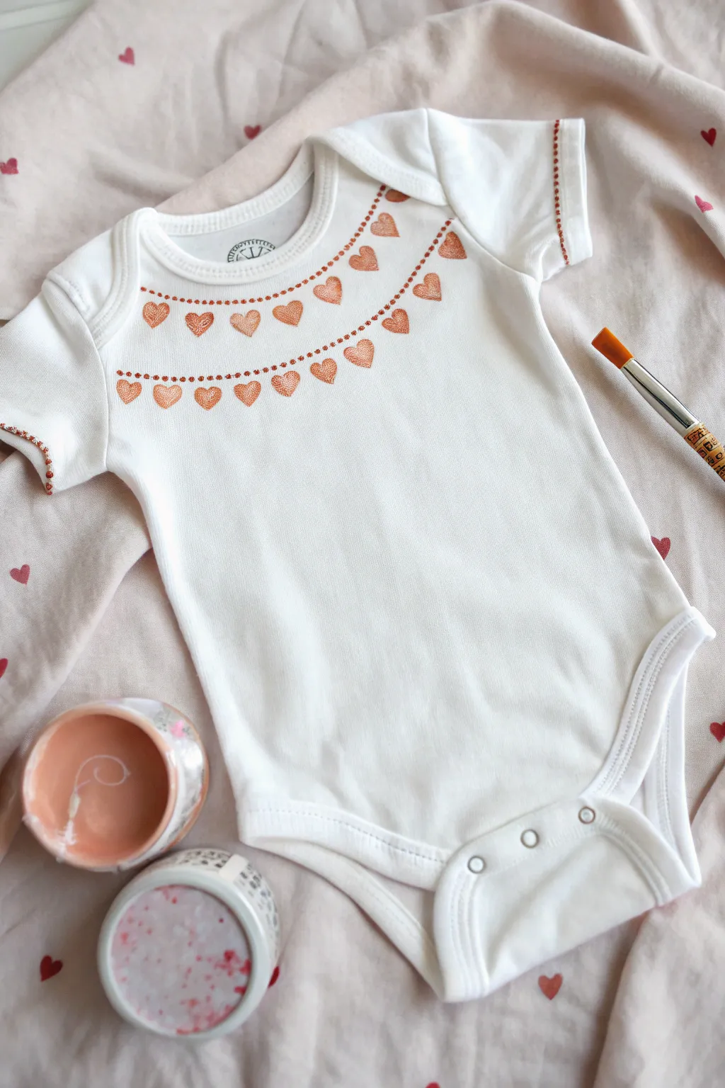 Sweet heart border baby onesie with soft fabric paint details, minimalist and cozy