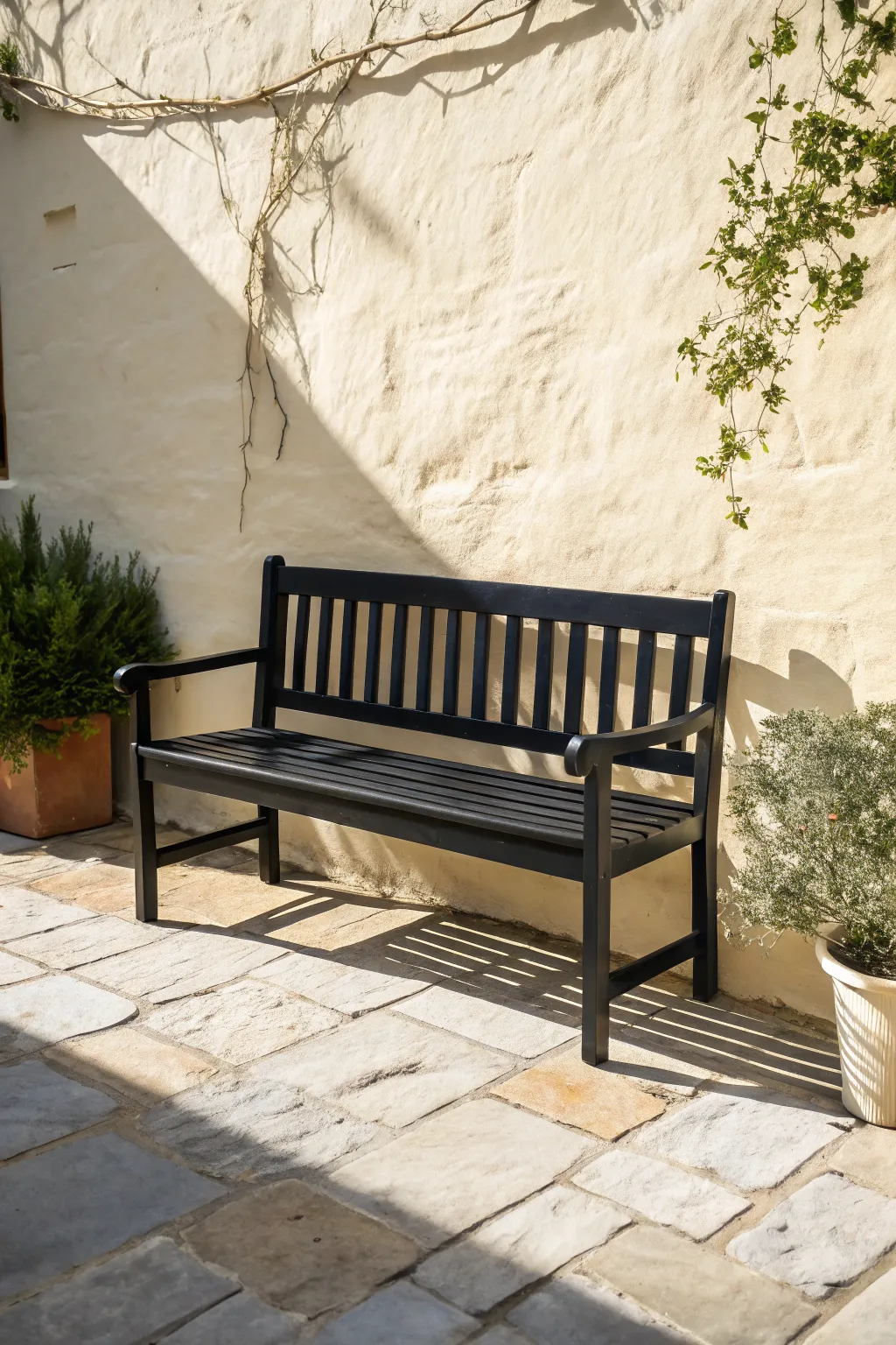 Matte black bench color idea: bold, modern contrast against pale stone and soft greenery.