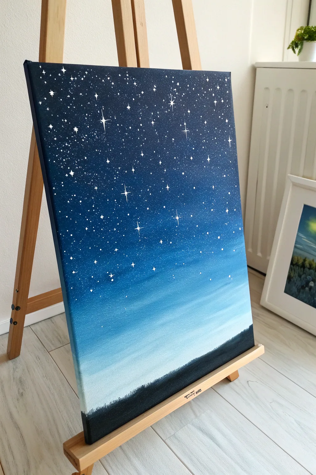Paint an easy night-sky ombre in blues with splattered stars and soft glowing clusters.