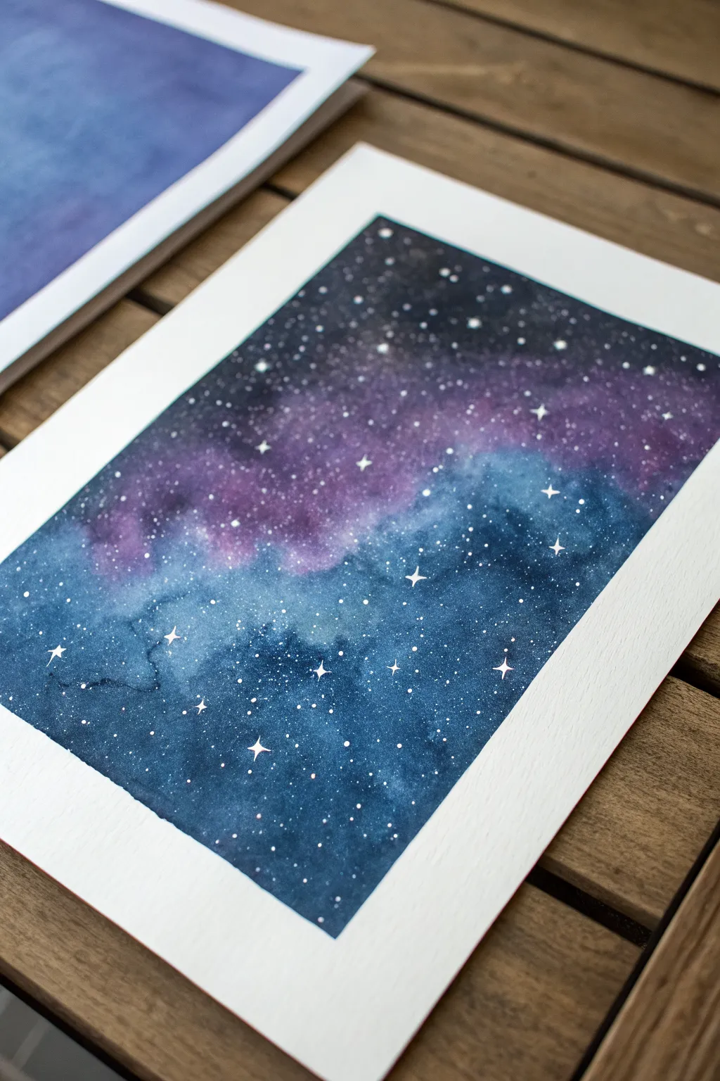 Misty watercolor galaxy wash with indigo and violet layers, finished with delicate splatter stars.