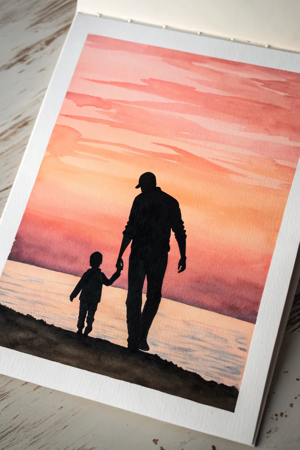 Simple dad and child silhouette against a warm sunset wash, perfect for a birthday keepsake.