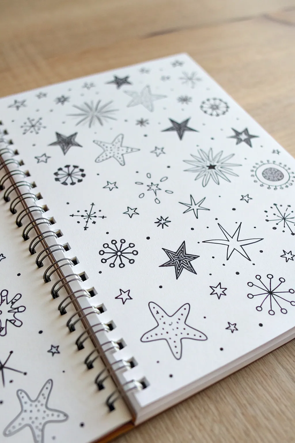 Crisp black ink stars, sparkles, and dot bursts on warm paper for effortless cute doodles
