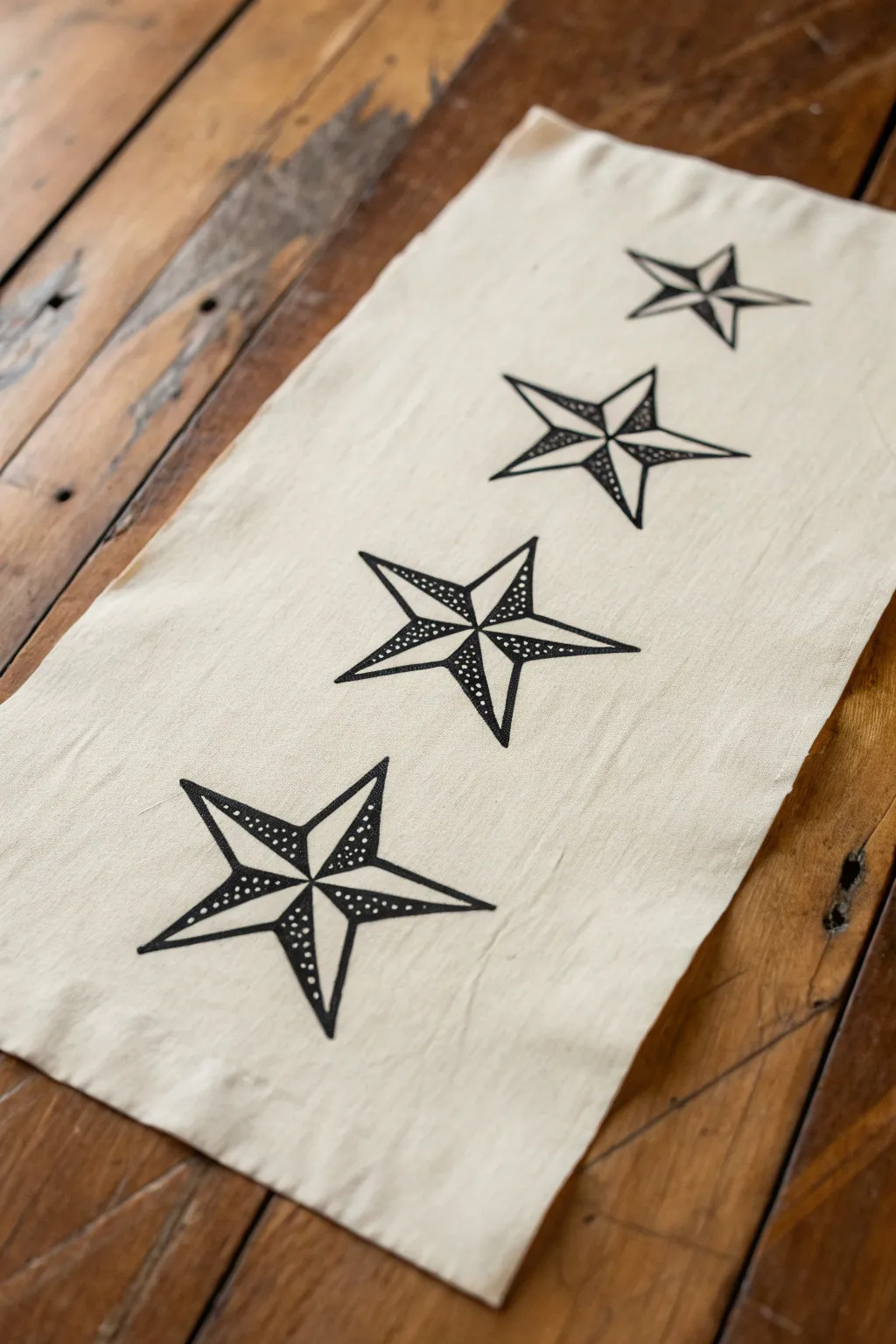 Four classic star tattoo fills in crisp black ink on warm paper, minimalist and bold.