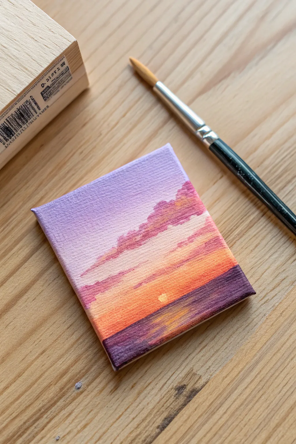 Paint a calm ombre sunset sky on a mini canvas with just a brush, palette, and warm hues