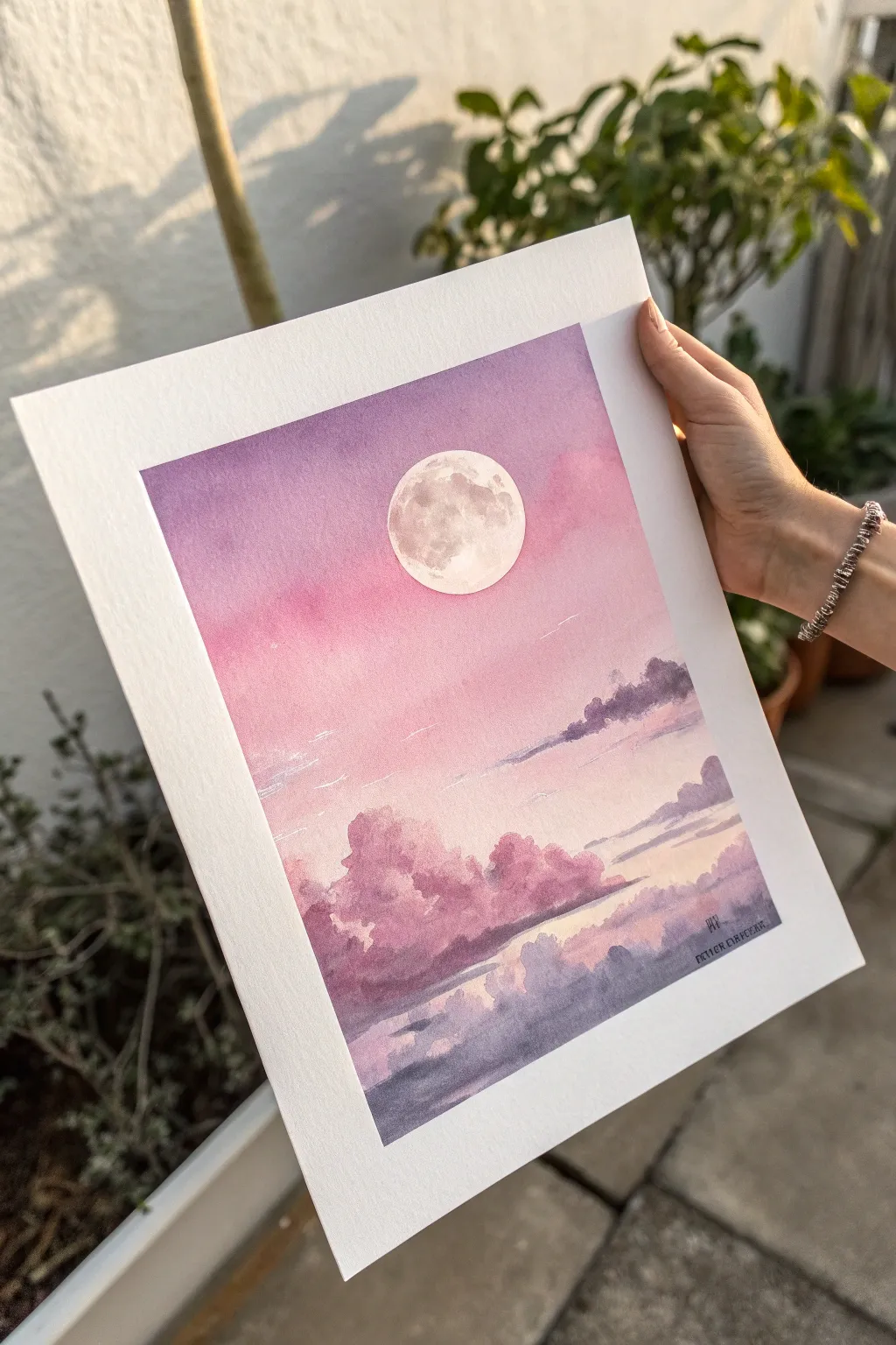 Dreamy pink sky with a crisp moon and softly blended lavender clouds in a clean, minimal style